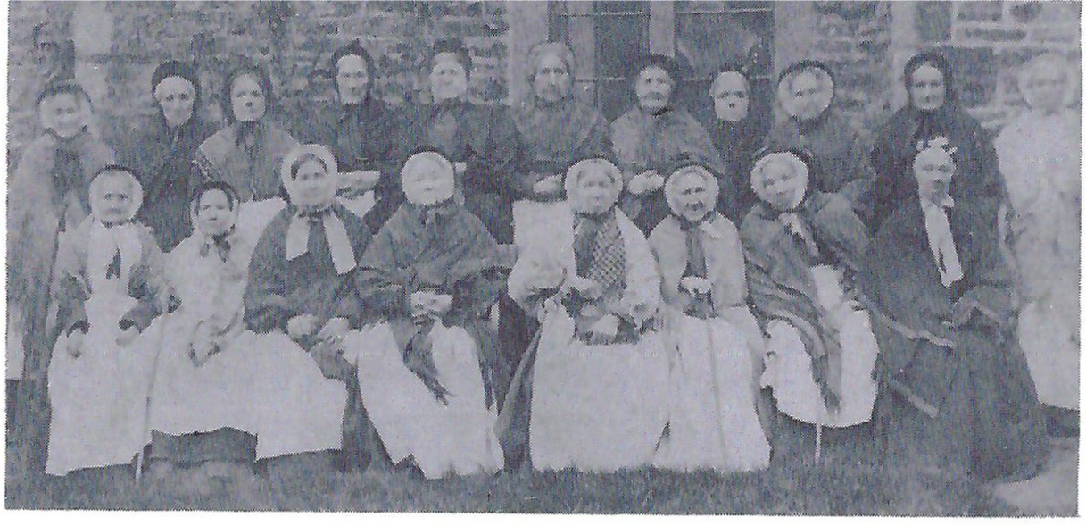 The ladies of the Blue House pose in front of the building in 1874. There were 20 residents including the one looking out of the window.