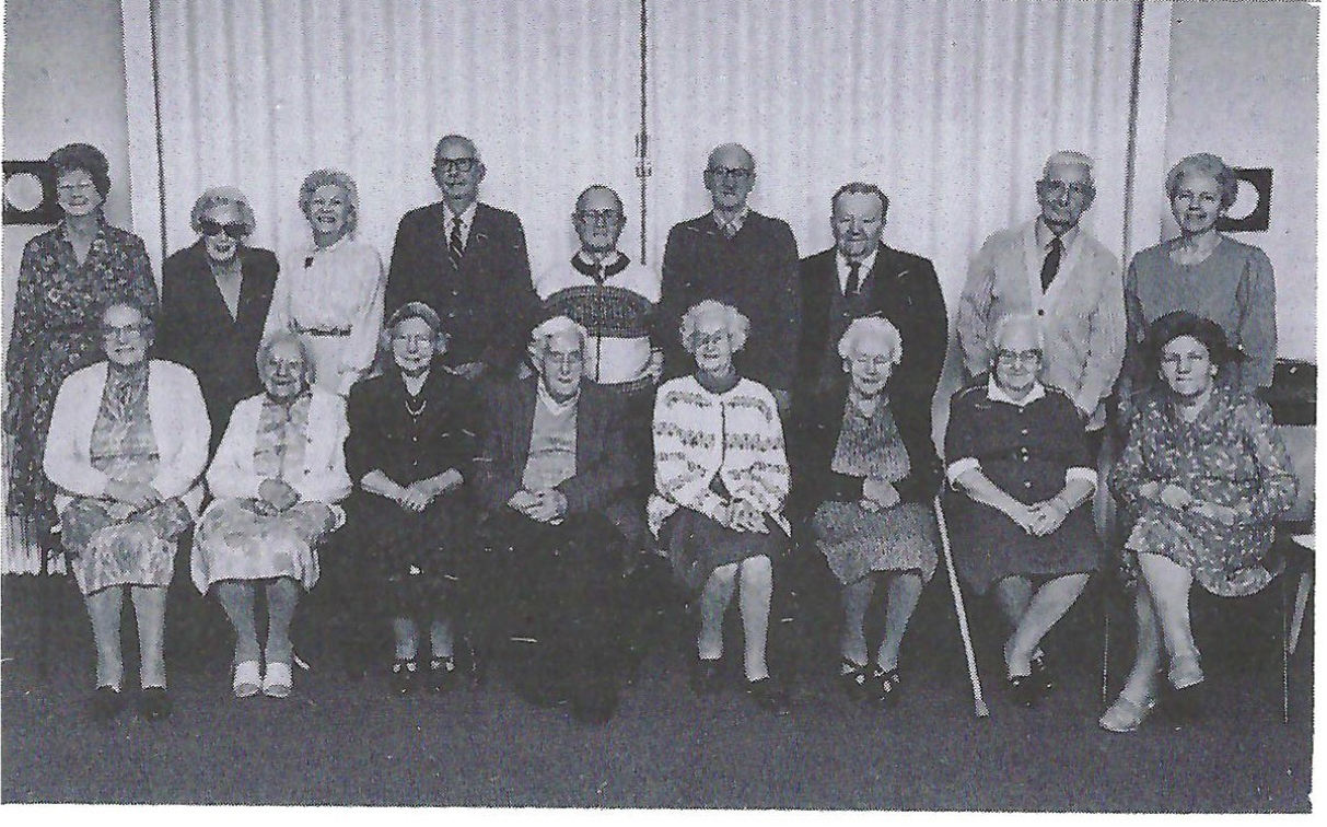 The residents of the Blue House with the Warden and Deputy Warden photographed by John Frapwell in November, 1992. They are (from left to right) front row sitting: Mrs. Ruby Parsons, Mrs. Elsie Shipley, Mrs. Irene Wilson, Mr. George Cansdell, Mrs. Florence Dimmack, Mrs. Eva King, Mrs. Gwen White, Mrs. Renee Tudgay. Standing: Mrs. Doreen Marshall (Warden), Mrs. Beryl Smart, Mrs. Wyn Cash, Mr. Fred Woolley, Mr. Bert Harding, Mr. Maurice Whittington, Mr. Arthur Bennett, Mr. Fred Corp, Mrs. Valerie Tucker (Deputy Warden).